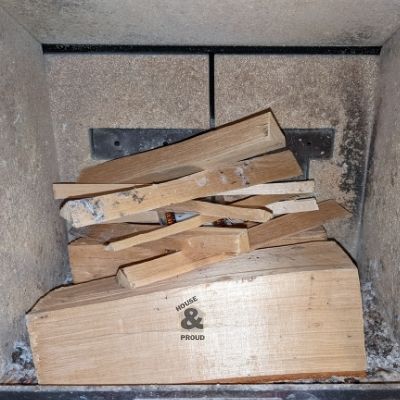 Triangular stack of kindling on top of some birch logs