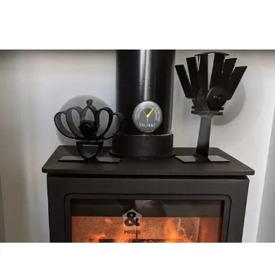 Two wood burning stove fans on a hot stove circulating warm air