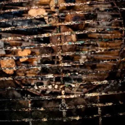 Using leftover wood ash to clean a BBQ grill that is dirty