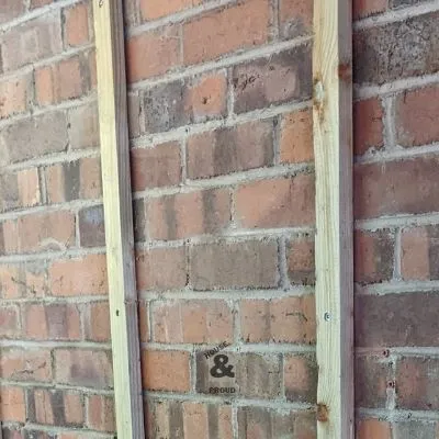 Wooden battens screwed onto a brick wall