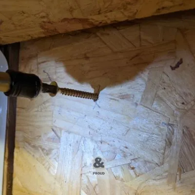 screwing drill bit organizing panel to garage wall